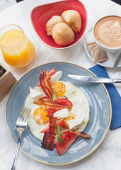 Delicious breakfast with eggs and bacon served in restaurant