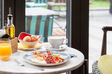 Delicious breakfast with eggs and bacon served in restaurant
