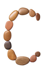 Letter C made of marine small pebbles, top view. Alphabet made of stones Isolated on a white background