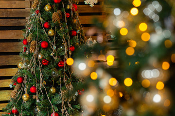 Red and gold Christmas ball on Christmas tree with light bulb on wooden wall background