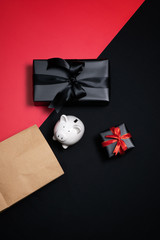 Top view of black gift box with red and black ribbons isolated on black background.