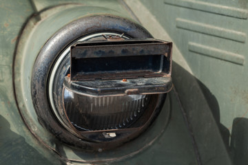 Round headlight of a military car with blackout cover