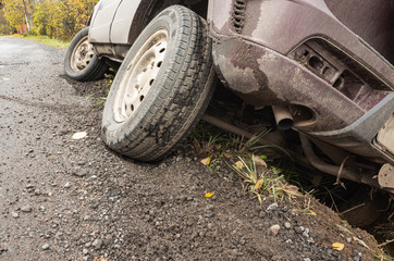 A car in an accident lies in a ditch, close up