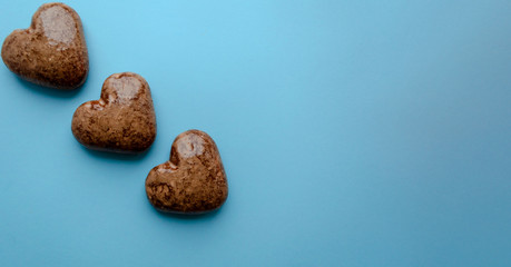 Valentine's flat lay with love chocolate gingerbread heart on colorful blue background, greeting card copy space top view. The celebration of Valentine's Day.