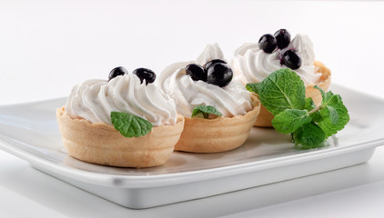 Homemade tartlets with cream cheese and fresh berries - currants and mint