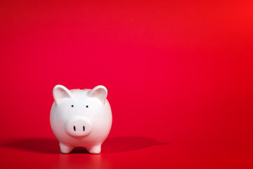 Composition with piggy bank isolated on red background.