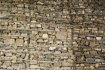 Gabion wall closeup. Textured background. Gabion is stones in wire mesh used for erosion control and slope reinforcement