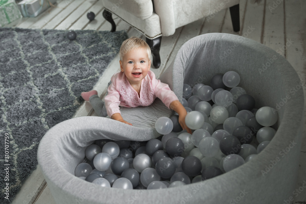 Wall mural the baby is playing in the pool with balls 2029.