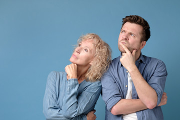 Fototapeta premium Caucasian family mother and som looking up standing over blue smiling. Studio shot. Positive facial human emotion.