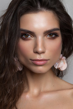 Photo of a beautiful brunette girl with hazel eyes and square jaw and chin. Perfect skin, light professional make up.