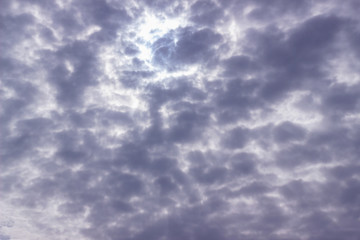 The sky with clouds in the summer is monochrome. Abstract natural sky background. Cloudy gray sky with clouds. The sun is covered with dark dense clouds.