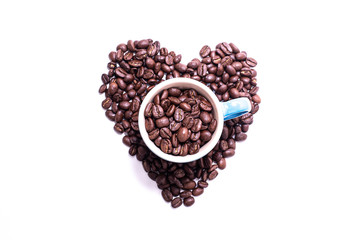 Heart shape created with coffee beans and a mug