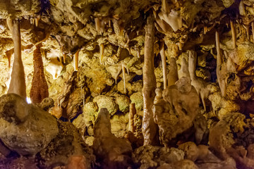 Various calcified formations, including stalactites and stalagmites, in a cave underground in Gozo island, Malta.