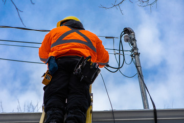 A low angle shot of a domestic service provider engineer installing new fiber optic cables to a...