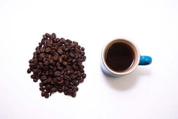 Blue cup of coffee by a pile of coffee beans