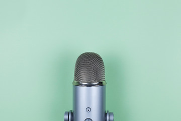 Closeup of professional microphone on mint background. Podcast studio concept. Electronic mic