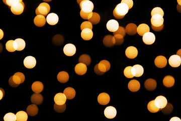 Abstract background with golden glitter light bokeh isolated on black background. It can be used as...