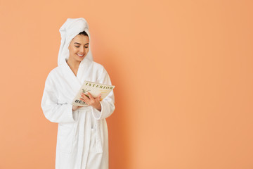 Beautiful young woman after shower reading magazine on color background