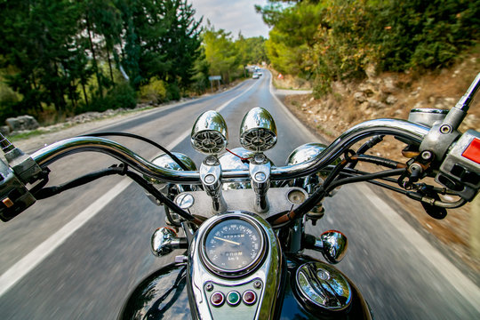 Man riding motorcycle and travelling on an empty country road. 