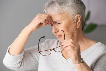 Senior woman suffering from headache at home