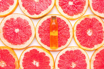 Bottle of essential oil on grapefruit slices