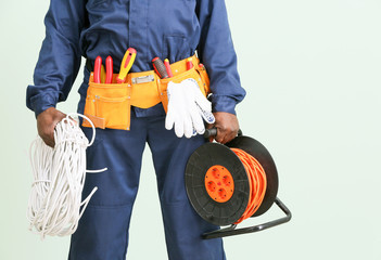 Fototapeta premium African-American electrician on color background