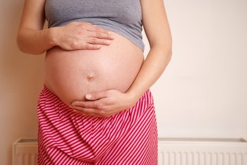 Midsection Of An Expectant Woman Touching Belly