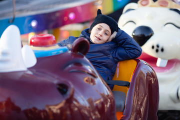 Little girl in winter clothes ride on the carousel Christmas Winter © Serghei
