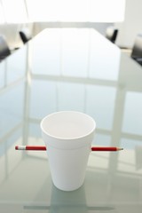 Disposable Cup Pierced By Pencil On Table