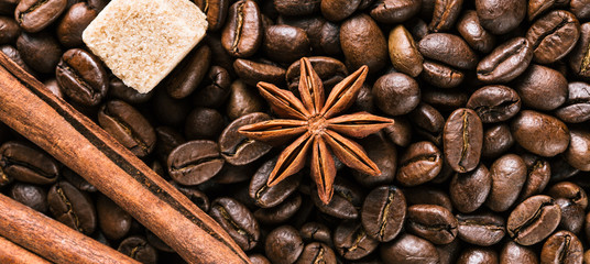 Coffee beans, anise star, cinnamon sticks and brown sugar, background, close-up