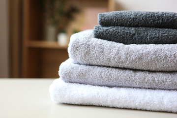 a stack of fresh towels on the table. - obrazy, fototapety, plakaty