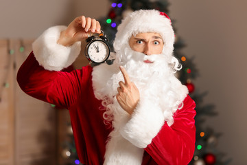 Santa with alarm clock in room. Christmas countdown concept