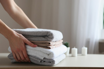 a stack of fresh towels in female hands.
