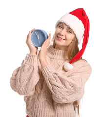 Young woman in Santa hat and with alarm clock on white background. Christmas countdown concept