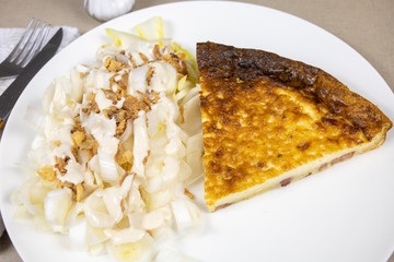 slice of quiche and endive salad