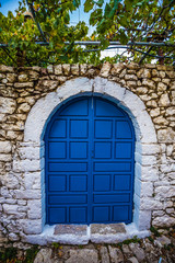 Fototapeta na wymiar Blue Gate In The Stone Wall