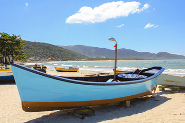 Naklejka na ściany i meble Solitary wooden fishing boat at sea beach with beautiful sky
