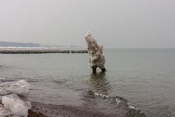 A strange ice figure coming out of the sea in winter