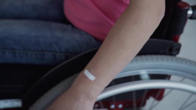 American disabled woman riding and turning sitting in wheelchair at home interior. Young handicapped female using medical chair for rehabilitation and recovery after injury. Concept: technology