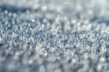 festive new year natural background with shiny transparent texture crystals of cold frost and snow cover the surface in the winter frosty morning