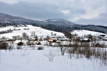 Village in the mountains. Huts on the background of snowy mountains.