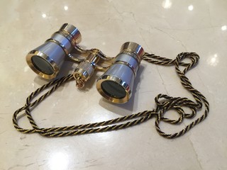 Theatrical binoculars close-up on a shiny marble surface
