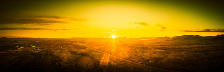 Drone panorama of a sunset over the Sonoran desert of Arizona with partly cloudy skies.