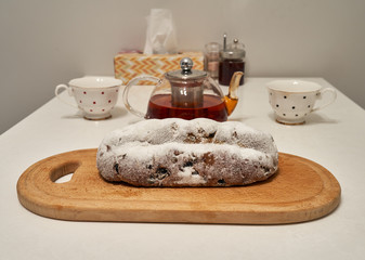 pie stollen with tea lies on a wooden board