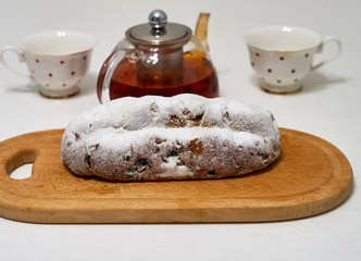 pie stollen with tea lies on a wooden board
