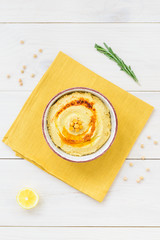 Hummus in a bowl on a wooden table.