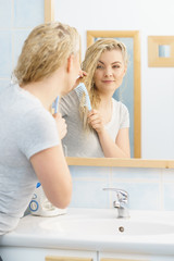 Woman brushing her wet blonde hair