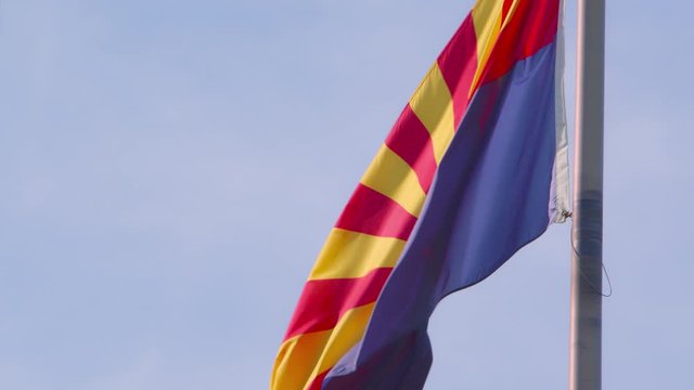 A backlit Arizona state flag blowing in the wind.
