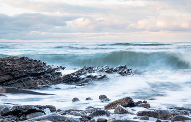Steinküste mit Klippen in stürmischem Atlantik mit Wischeffekt
