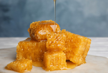 Fresh delicious dripping honey on white table, closeup